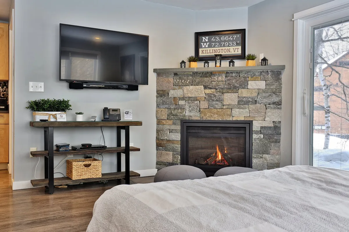 A cozy interior living area featuring a gas fireplace, TV, and comfortable seating. The inviting setting is perfect for unwinding, streaming shows, and sharing stories after a day on the mountain.